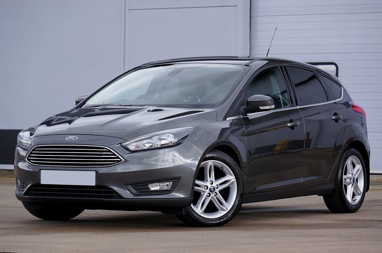 A sleek grey hatchback car parked outdoors, showcasing its modern design and shiny finish.