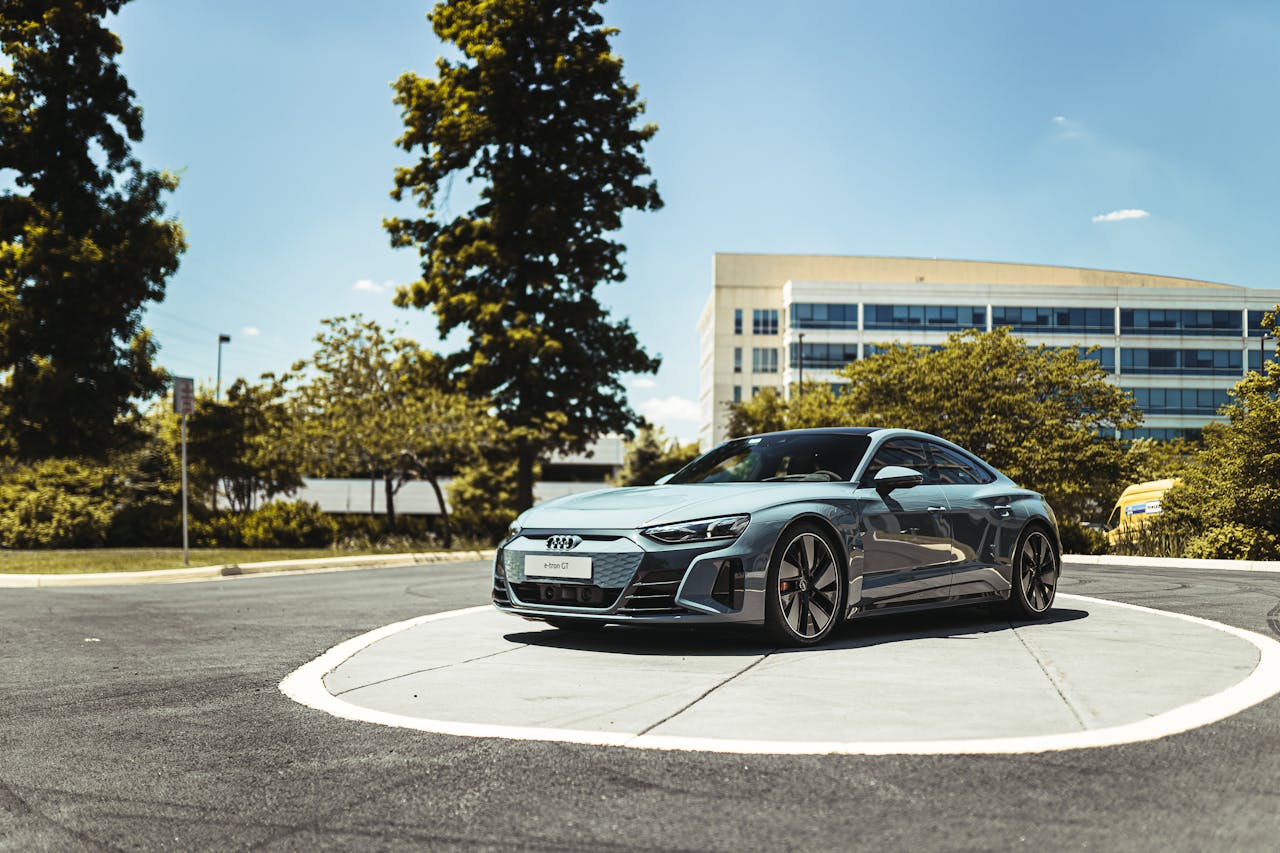 Luxurious Audi car in a modern cityscape with blue skies and greenery. Perfect for automotive enthusiasts.
